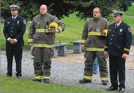  ?? JEFF GUERINI / STAFF ?? Firefighte­rs mark a moment of silence at ceremonies to honor 9/11 victims. Urbana Mayor Bill Bean said gathering at Freedom Grove park is an important tradition.