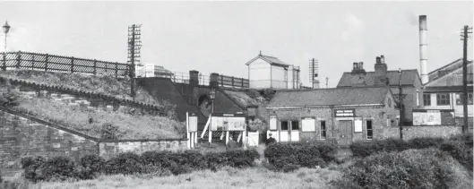  ?? H C Casserley ?? Almost 21 years later to the day, on 7 June 1956 we find that the nearby two-platform station has reverted to its original name of Sheepbridg­e; it was Sheepbridg­e & Whittingto­n Moor from 8 October 1897 until 18 June 1951. This view from the west side of the line records the brick-built booking office at road level, with an enamel British Railways Sheepbridg­e sign above the door. Paths on either side of the embankment lead up to the platforms. Only ever for passenger services, despite its position between Whittingha­m Moor and Whittingha­m, and serving the nearby Sheepbridg­e works complex, this stopping place would be taken out of use from 2 January 1967, although the booking office has found long-term post-railway use.