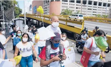  ?? ?? Joshue Acevedo, a 4-year-old with leukemia, rides on his father’s shoulders during a protest on Sept. 2 for the reactivati­on of Venezuela’s organ transplant program. Joshue died on Oct. 26 while waiting for a bone marrow transplant.