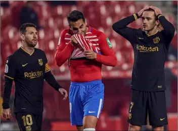  ?? AP Photo ?? Barcelona’s Antoine Griezmann (right) reacts next to Barcelona’s Lionel Messi (left) during a Spanish Copa del Rey quarter finals soccer match between Granada and FC Barcelona at the Los Carmenes stadium in Granada, Spain, on Wednesday.