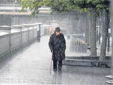  ?? Picture: Graeme Hart. ?? Summer in Perth… A man makes his way along Tay Street through torrential rain.