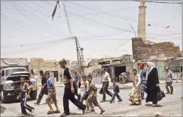  ?? Associated Press ?? Residents walk past the crooked minaret called al-Hadba, or “hunchback,” in a busy market area in Mosul, Iraq, in 2009. Iraq’s ministry of defense says Islamic State militants destroyed the al-Nuri mosque in Mosul and the adjacent iconic leaning...