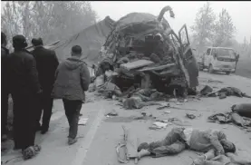  ?? — AFP ?? The bodies of victims lie scattered on the road after a bus and truck collided in Xiaoxian county, in eastern China’s Anhui province, on Thursday, killing at least 24 people and injuring two, local authoritie­s said.