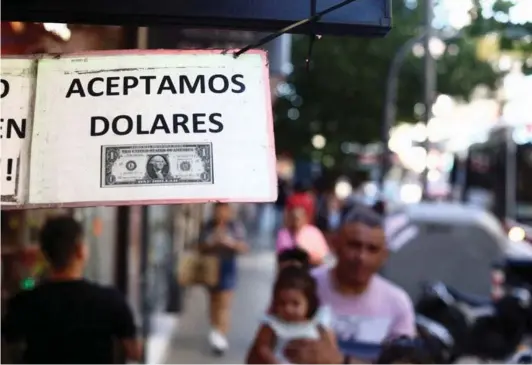  ?? ?? ►Un cartel fuera de una tienda dice “Aceptamos dólares” en Buenos Aires, el 12 de diciembre de 2023.