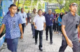  ?? REUTERS ?? A foregone conclusion: Maldives President Abdulla Yameen (centre), who is expected to win the election, arrives to cast his vote at a polling station in Male on Sunday.