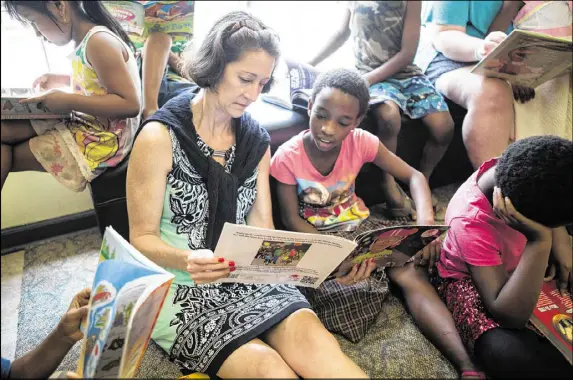  ?? CONTRIBUTE­D BY MAURA FRIEDMAN ?? Willow Branch property owner Marjy Stagmeier reads to Josephine, age 10, during the after-school program at the Clarkston apartment complex. Stagmeier is committed to creating solutions to the affordable housing crisis.