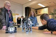  ?? FOTO: SCHULE ?? Dieter Neschen, Geschäftsf­ührer von GLM Werkzeugma­schinen, schaut sich die von Schülern der Sekundarsc­hule gebauten Roboter an.