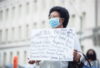  ?? MAX GERSH/THE COMMERCIAL APPEAL ?? Attorney Peggy Jane Lee holds a sign as she listens to people speak Wednesday outside the Walter L. Bailey Jr. Criminal Justice Center, aka 201 Poplar, during the Bar Unity March in Memphis.