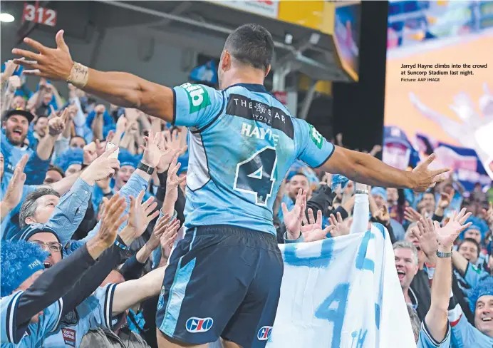  ??  ?? Jarryd Hayne climbs into the crowd at Suncorp Stadium last night. Picture: AAP IMAGE