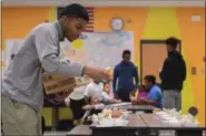  ?? ERIC BONZAR — THE MORNING JOURNAL ?? Lorain High School senior Ke’Andre Davis, 18, plates cups of tropical fruit on to meal trays Feb. 7, during the Boys and Girls Clubs of Lorain County’s after school program at Frank Jacinto Elementary School.