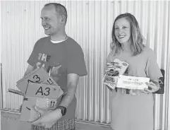  ?? [PHOTO BY CARLA HINTON, THE OKLAHOMAN] ?? Adam and Bernadette Wile show a box of Hot Wheels cars and children’s books before distributi­ng the items to youths and families at the Barrett Field Splash Pad on July 9 in Edmond.