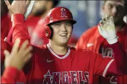  ?? TED S. WARREN — THE ASSOCIATED PRESS FILE ?? Los Angeles Angels’ Shohei Ohtani is greeted in the dugout after he hit a solo home run during the first inning of a baseball game against the Seattle Mariners, Sunday, Oct. 3, 2021, in Seattle. Ohtani, the Los Angeles Angels’ twoway superstar, is the winner of The Associated Press’ Male Athlete of the Year award.