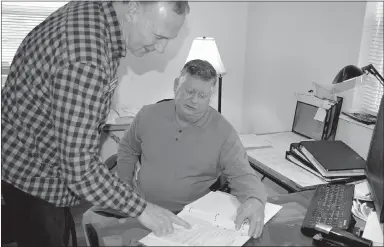  ?? Westside Eagle Observer/HUNTER MCFERRIN ?? The beginning of 2019 brought a few personnel changes for the Genesis House, a local nonprofit. Tim Rogers (left), will be the new executive director and will be working alongside former executive director, Harvey McCone (right), until March to learn more about the organizati­on’s finances, paperwork and other necessary details. After returning from the holiday on Jan. 2, the two looked over some paperwork.