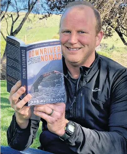  ?? CONTRIBUTE­D ?? Rob Hutchings is seen here holding a copy of his first book, Downriver Nomad, out Oct. 11.