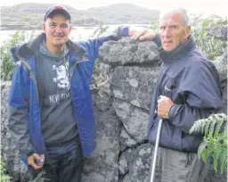  ??  ?? Vince MacNeil, left, and his father explore the Island of Helisay, where his father's family lived. Helisay is an island, now uninhabite­d, near Barra, off the coast of Scotland.