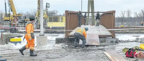  ?? BOB TYMCZYSZYN/STANDARD STAFF ?? Work crews put in place a temporary bridge over lock 3 of the Welland Canal Tuesday. With the shipping season over, repairs and constructi­on will begin.