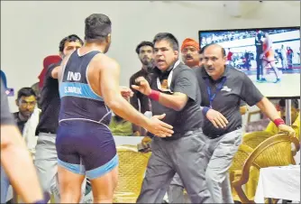  ?? SANJEEV VERMA/HT ?? Wrestler Satender Malik assaults referee Jagbir Singh after his loss at the CWG trials at IG indoor stadium on Tuesday.