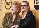  ??  ?? In this Jan 25, 2015 file photo, Debbie Reynolds, winner of the Screen Actors Guild lifetime award, left, and Carrie Fisher pose in the press room at the 21st annual Screen Actors Guild Awards in Los Angeles.