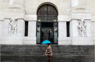  ?? (Alessandro Garofalo/Reuters) ?? A WOMAN WALKS past Milan’s stock exchange building.