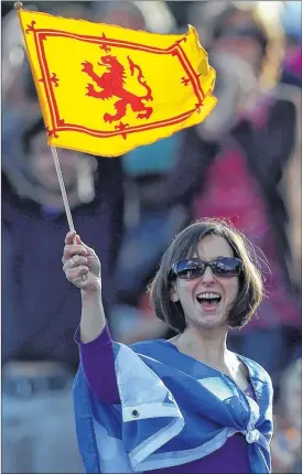  ?? Picture: Clive Rose/Getty Images ?? FLYING THE FLAG: A spectator at the Killearn Street Open celebrates the arrival of a piece and sugar from the third floor window.