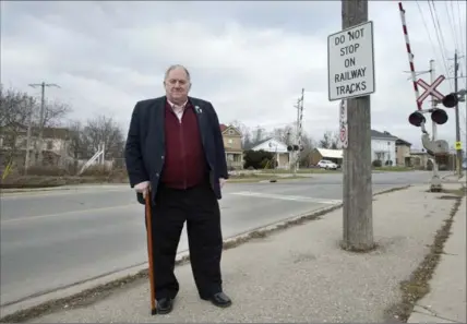  ?? MATHEW MCCARTHY, RECORD STAFF ?? Wilmot Township Mayor Les Armstrong stands at railway crossing near the intersecti­on of Waterloo and Steinman streets in New Hamburg. Waterloo Region recently put up no-left-turn signs at the intersecti­on because of concerns traffic could back up onto...