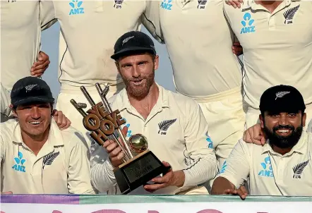  ?? GETTY IMAGES ?? Captain Kane Williamson tightly grips the series trophy after his New Zealand team sealed a famous 2-1 test series win over Pakistan in Abu Dhabi yesterday.