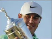  ?? DAVID J. PHILLIP — THE ASSOCIATED PRESS ?? Brooks Koepka poses with the winning trophy after the U.S. Open golf tournament Sunday at Erin Hills in Erin, Wis.