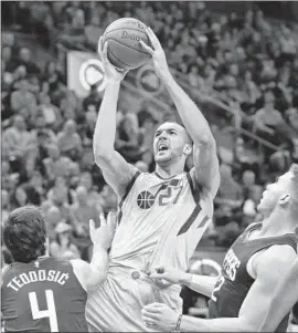  ?? Rick Bowmer Associated Press ?? RUDY GOBERT of the Utah Jazz goes to the basket between Milos Teodosic and Blake Griffin of the Clippers in the second half. The Clippers lost 125-113.