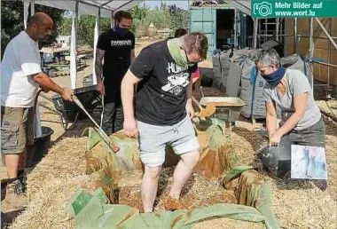  ?? Fotos: Luc Deflorenne ?? Mehr Bilder auf www.wort.lu
Für die unterste Putzschich­t wird der Lehm mit gehäckselt­em Stroh vermischt. Die Helfer scheuen sich nicht, dafür in eine improvisie­rte Wanne zu steigen.