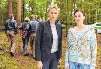  ?? Foto: Barbara Bauriedl, ZDF ?? Entsetzen im Wald: Während Polizisten eine Person abführen, starren Lena Fauch (Veronica Ferres) und Melanie Knapp (Bettina Mittendorf­er) auf das Geschehen im Wald.