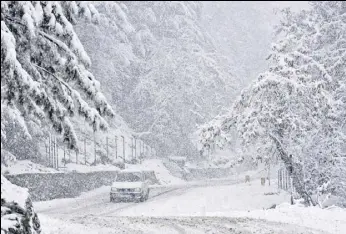  ?? WASEEM ANDRABI/HT ?? A vehicle drives past a snowcovere­d Gulmargtan­gmarg road in Srinagar on Monday.