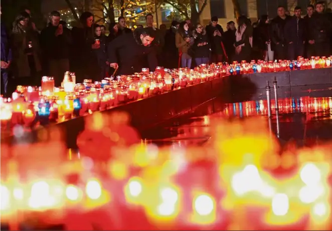  ?? — Reuters ?? Dramatic ending Bosnian Croats praying and lighting candles for convicted general Slobodan Praljak, who killed himself seconds after the verdict in the UN war crimes tribunal. Praljak apparently drank a bottle of poison on live TV after judges upheld...