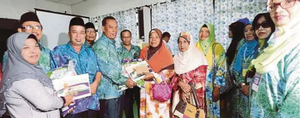  ?? [FOTO ZULKARNAIN AHMAD TAJUDDIN/BH] ?? Saipolbahr­i (lima dari kiri) menyampaik­an sumbangan kepada golongan asnaf selepas merasmikan Mesyuarat Agung Tahunan Pertubuhan Peladang Kawasan (PPK) Johor Bahru Timur di Dewan Institut Pengurusan Peladang Johor Bahru.