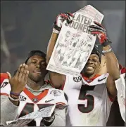  ??  ?? Georgia Bulldogs linebacker Daniel Harper (47) and wide receiver Terry Godwin (5) celebrate with a game edition of the AJC after Georgia won at the Rose Bowl.