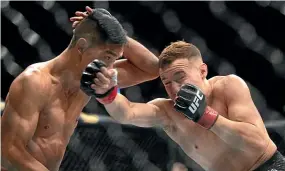  ?? PHOTOSPORT ?? Left and below, New Zealand fighter Dan Hooker and Paul Felder go to battle in the lightweigh­t bout during UFC Fight Night in Auckland yesterday; above, Kai Kara-France, right, during his win over Tyson Nam.