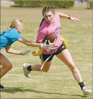  ?? Westside Eagle Observer/RANDY MOLL ?? Alyssa McCarty (a senior) runs the ball while McKenzie Barnes (a sophomore) reaches for her flags during Wednesday’s powder puff football game in Gentry.