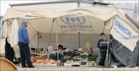  ?? Picture: REUTERS ?? CAPTIVE MARKET: Syrian refugees sell vegetables outside their tent in the Zaatari refugee camp in Jordan. Many similar businesses have opened in the camp, which is near the Syrian border, and although they break labour or other laws they are making...