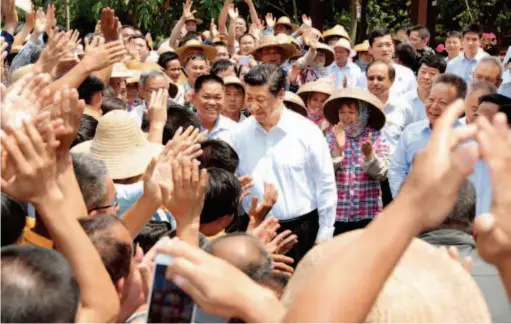  ??  ?? April 13, 2018: Chinese President Xi Jinping shakes hands with villagers during his visit to Shicha Village, Shishan Town, Xiuying District, Haikou. Under the leadership of the Communist Party of China (CPC) Central Committee with General Secretary Xi Jinping at the core, Hainan has launched a new round of practice and exploratio­n of reform and opening up since the 18th CPC National Congress in 2012. by Xie Huanchi/xinhua