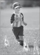  ??  ?? Two-year-old Harrison Mehes runs through the pylons at soccer