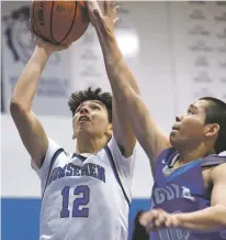  ?? LUKE E. MONTAVON/NEW MEXICAN FILE PHOTO ?? St. Michael’s Thomas Wood, left, shoots over Laguna’s Andre Chino during a Jan. 10 game in the Horsemen Shootout.