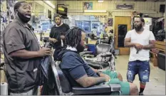  ?? Stephen Speranza / Washington Post ?? Brian Mcfadden, left, of Bee’s Famous Barbershop in the Bronx gives son Edward Mcfadden a trim.