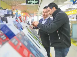  ??  ?? Seref Yigit (left) introduces his products to a customer.