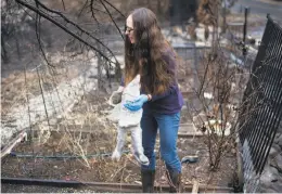  ??  ?? Lisa Tieber Nielson, salvaging a garden gnome that she's had since childhood, says a better warning system could have helped prevent deaths.