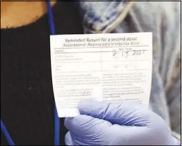  ??  ?? Sharda Smith, registrati­on lead with the Southern Nevada health District, holds up a second dose reminder card at the site.