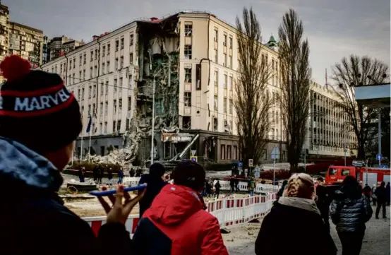  ?? LAURA BOUSHNAK/NEW YORK TIMES ?? Pedestrian­s passed a hotel on Saturday that was badly damaged by a Russian airstrike in Kyiv, as multiple blasts hit the city.