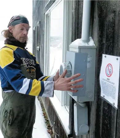  ??  ?? Olivier Burnham vend 25 $ des « cadenas » qu’il fixe sur les compteurs afin d’empêcher leur remplaceme­nt. Il suggère à ses client d’installer une affiche mettant en garde Hydro-Québec.