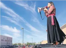  ?? THE ASSOCIATED PRESS ?? Amanda Blackhorse speaks through a megaphone during protest outside the Phoenix office of Yandy.com, a retailer of “sexy Native American” costumes.