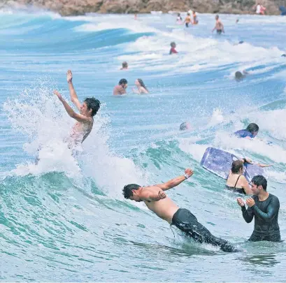  ?? Picture / Alan Gibson ?? Everyone was heading for the water to cool off at Mt Maunganui beach yesterday.