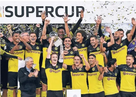  ?? FOTO: MARTIN MEISSNER/AP ?? Dortmunds Marco Reus reckt den Supercup in die Höhe und feiert mit dem Team den ersten Titel der neuen Saison.