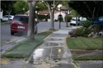  ??  ?? Sprinklers water the lawn of a house and the sidewalk in Alameda, on Tuesday, May 4.